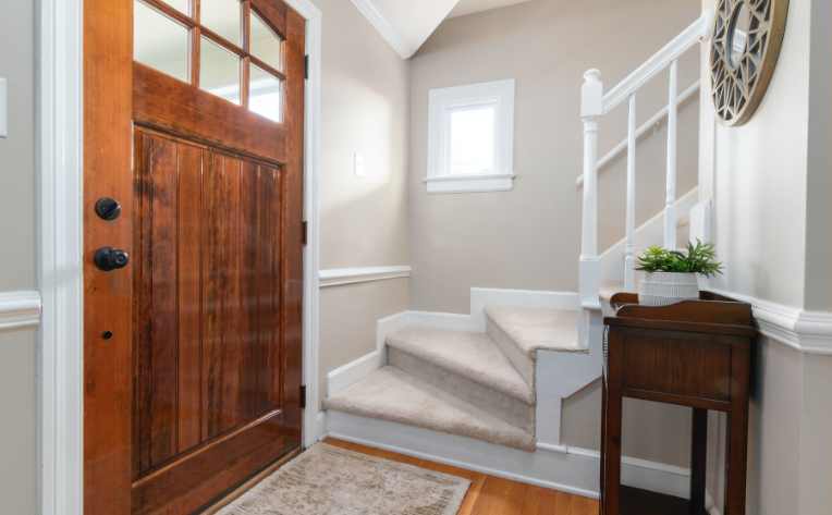 neutral carpeted staircase in traditional entryway to home